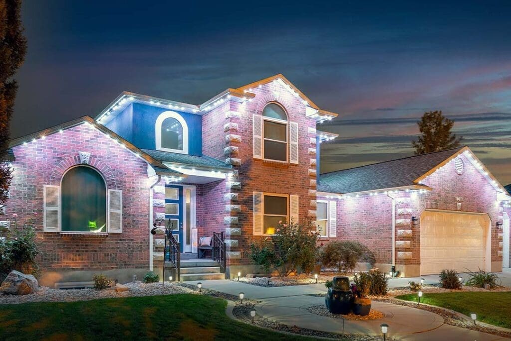 Home at dusk with soft pink accent lights along the roofline