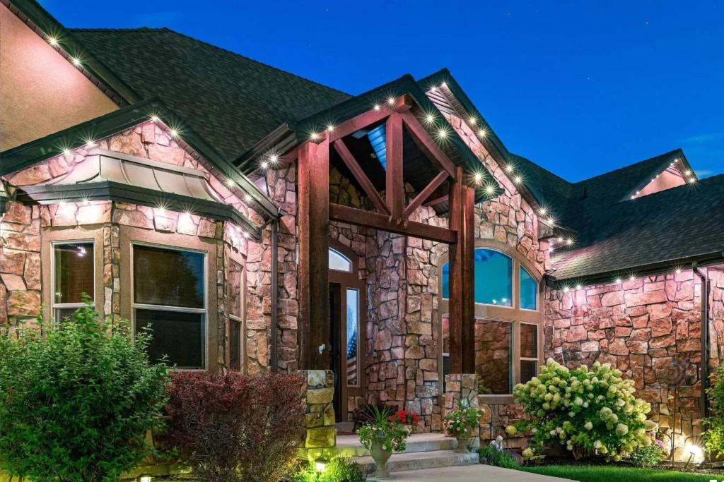 Stone and timber home at dusk with warm accent and landscape lighting