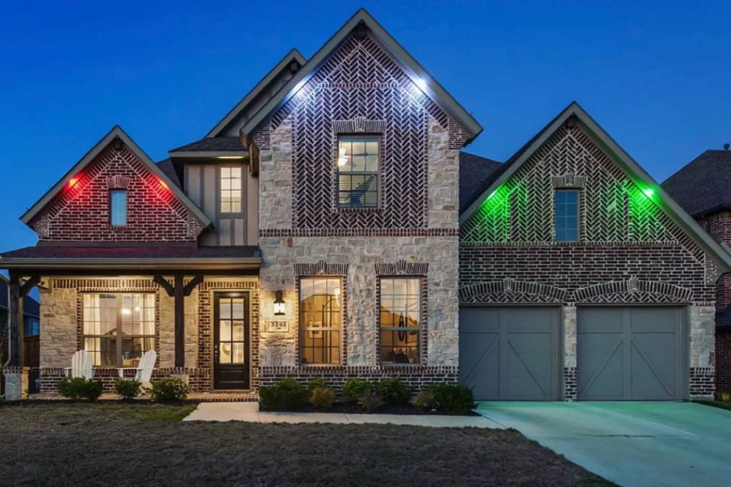 Two-story home at dusk with red and green holiday lights on each gable