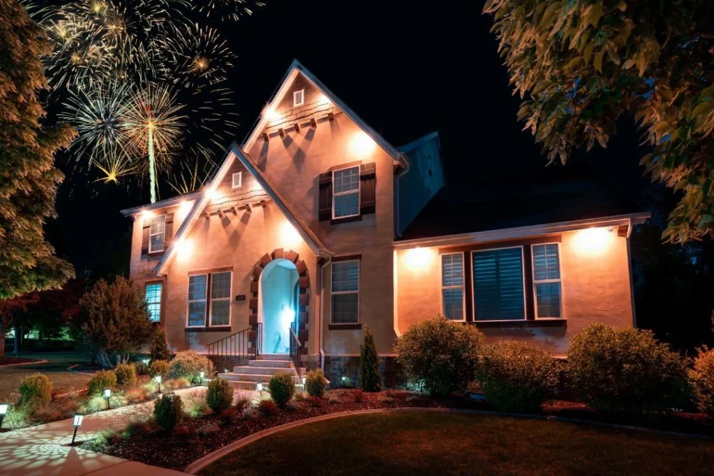 Home at night with warm downlights and fireworks overhead