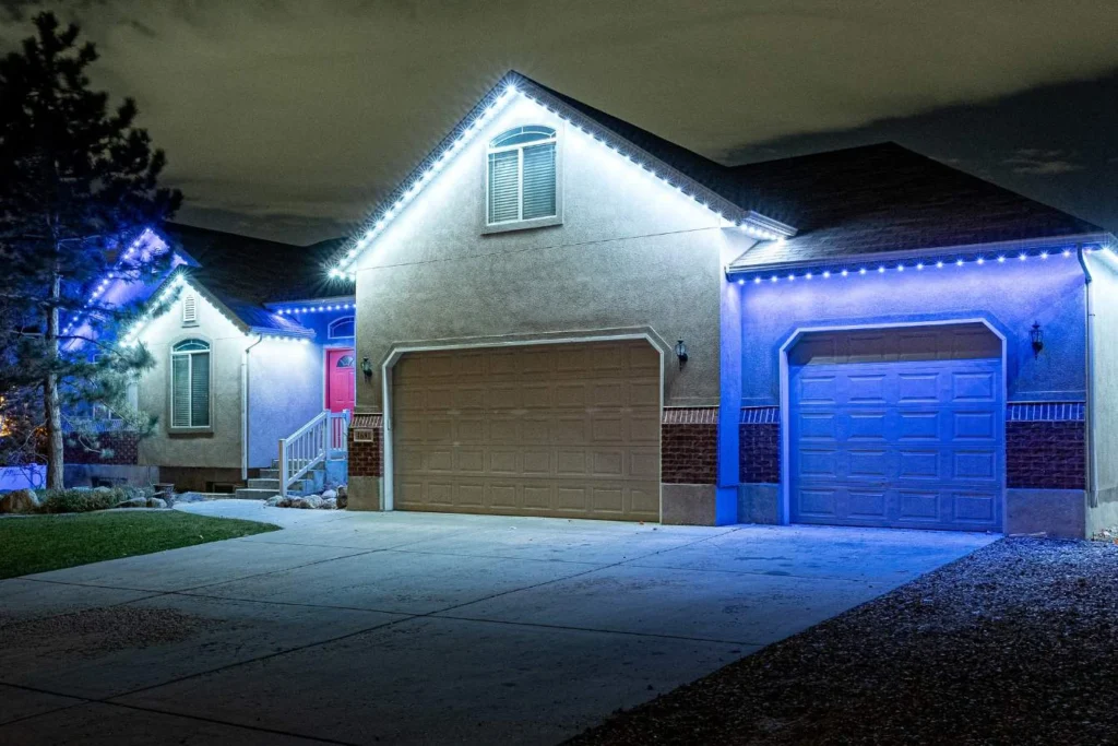 Garage and entry at night lit with white and blue downlights
